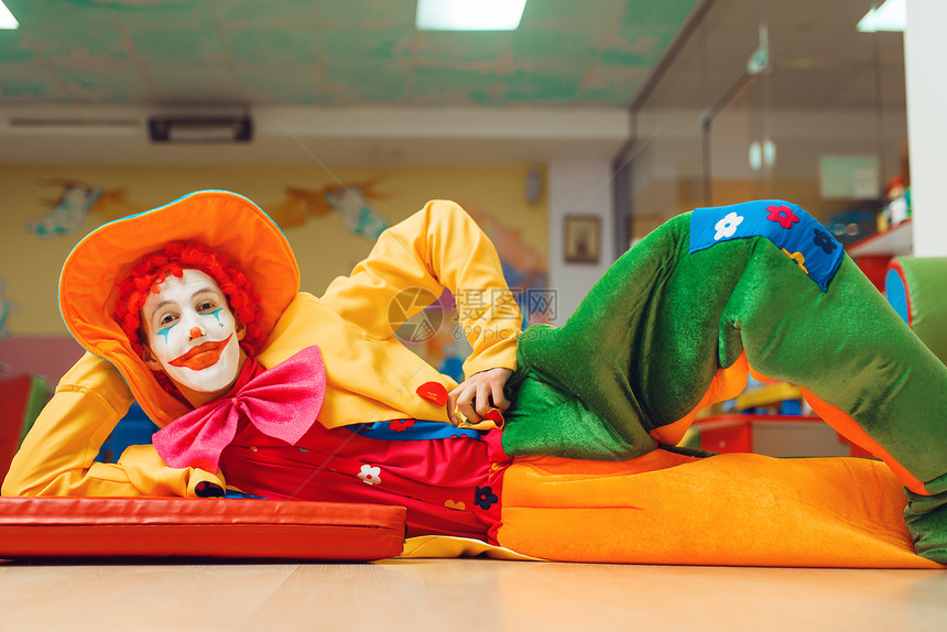 滑稽的小丑躺在地板上图片
