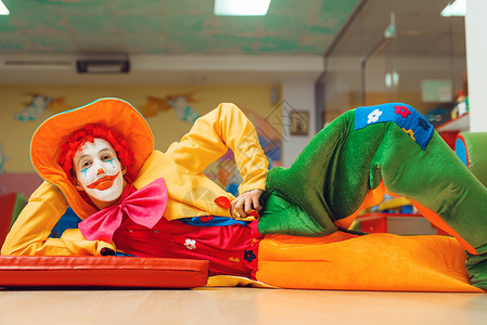 滑稽的小丑躺在地板上图片