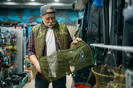 网商在渔场中选择网的男角人在渔场中选择网在背景上选择钩子和baules在渔场中选择网的男角人在渔场中选择捕和狩猎的设备工具在商店中的背景
