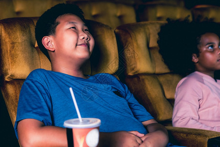 三个孩子玩得开心在电影院看剧院高清图片素材