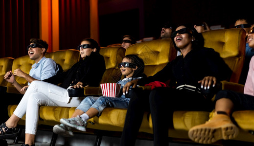 一群人在电影院看带着3D眼镜看电影有兴趣屏幕奋和吃爆米花图片