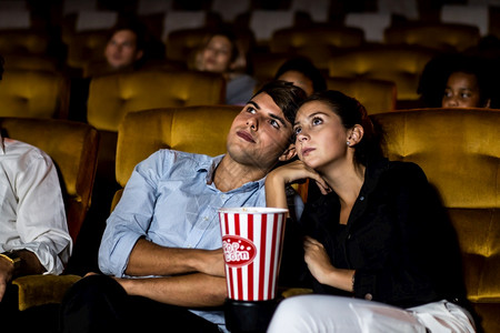 一对情侣在电影院看电影父母高清图片素材