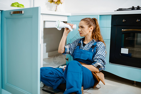 女水管工在厨房修理排水管时遇到问题女水管工在修理排时遇到问题女性的高清图片素材