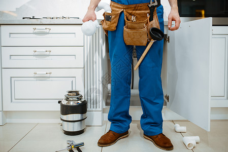 男水管工在厨房安装水过滤器工具袋高清图片素材