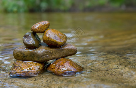 在河中平衡岩石或头的塔平衡岩石的巨型图象背景图片
