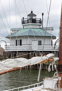 与灯塔一起在切萨皮克湾端有游艇和停泊在码头的上船只图片