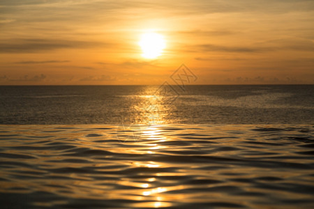 日落时俯视海洋的无限游泳池边缘图片