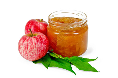 苹果果酱玻璃罐中的苹果酱新鲜的红苹果树枝和白背景上孤立的叶子背景