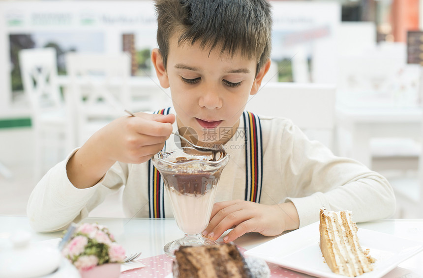 儿童在餐桌上吃牛奶和巧克力昔图片