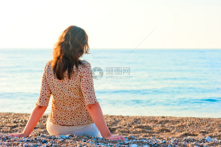坐在沙滩上欣赏大海的女人图片