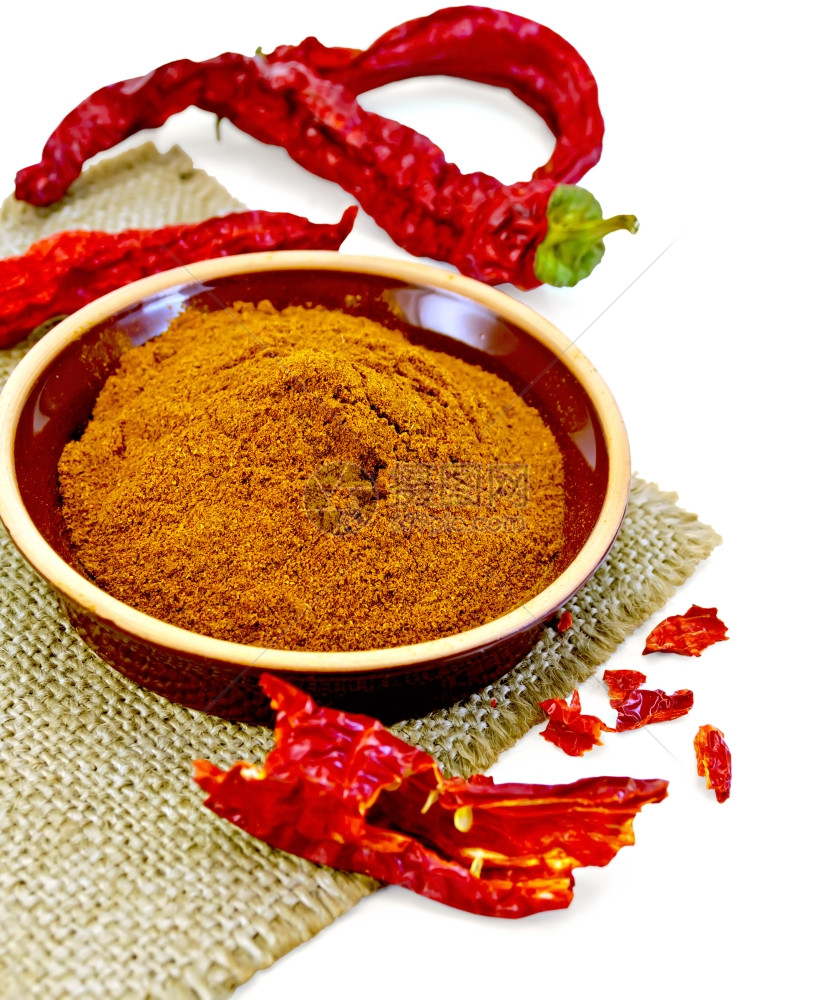 粘土碗中的红色辣椒粉白底被孤立的打发餐巾纸上红色辣椒粉和片图片