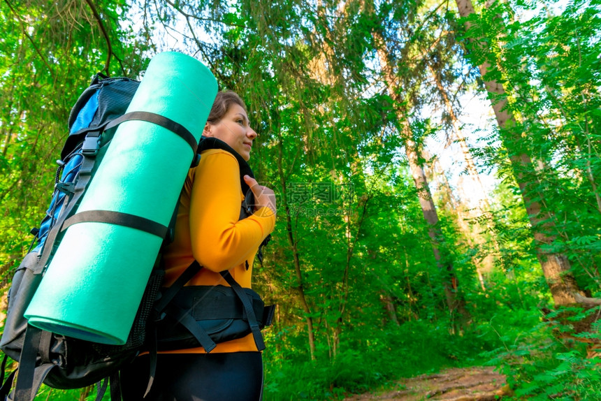 旅游者背着包在树林里寻找道路图片