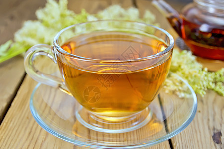 一杯茶壶和里的草地甜鲜的草地甜花放在木板上背景图片