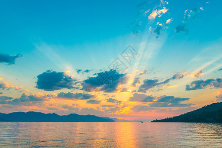 在海面的太阳升起光芒下美丽天空背景图片