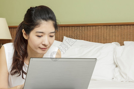 在卧室用电脑工作的妇女亚洲的高清图片素材