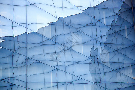 蓝色天空反射的现代玻璃建筑几何形状外表一部分图片