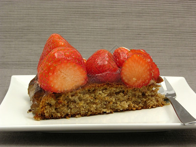 一片草莓蛋糕白盘上一片草莓蛋糕灰色背景图片