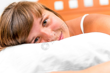 快乐的女孩趴在床上微笑白天高清图片素材