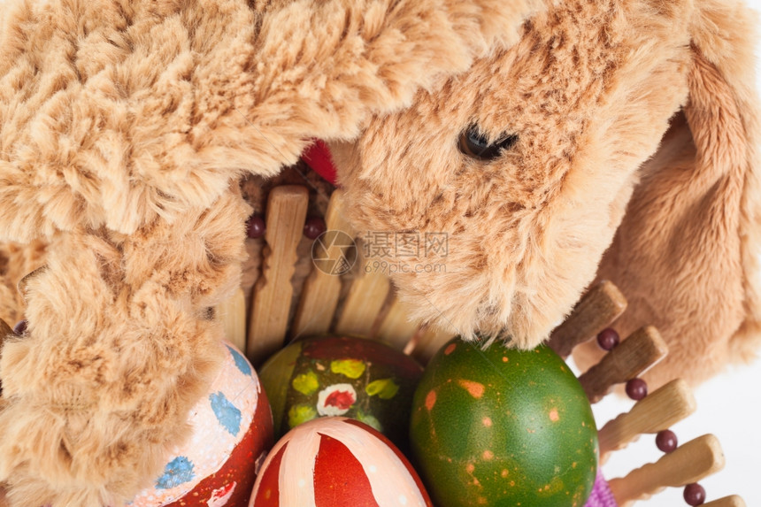 兔子拿着五彩缤纷的复活节彩蛋在篮子里为快乐的节日图片