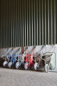 旧的独轮手推车停靠在农场谷仓里背景图片