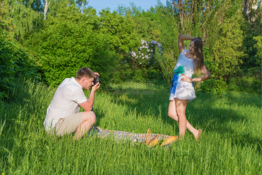 男子在公园为女友拍摄照片图片