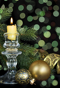 以绿色调装饰圣诞节用燃烧的蜡烛玻璃球和黑色背景的美丽bokh图片