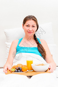 在床上吃早餐的女人图片