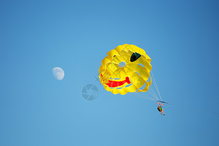 被拖走表情包一艘降落伞在海上被拖走背面是蓝色的天空左边是月亮背景