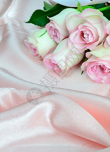 粉红玫瑰圆礼盒和丝织物背景上的珍珠项链垂直图象图片