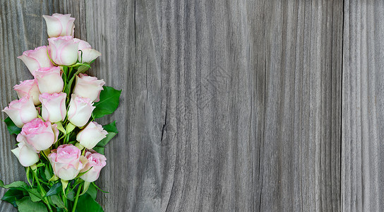 旧灰色木板背景上的粉红玫瑰花束图片