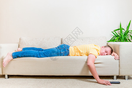 男人在客厅看电视后睡在沙发上图片
