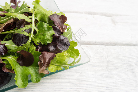 新鲜绿色沙拉盘子里有菠菜青萝卜和生菜高清图片