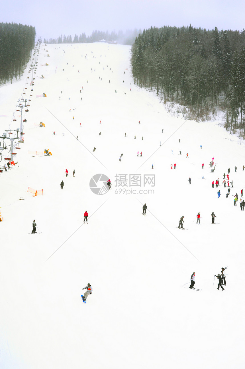 在大雪降期间在天空度假胜地的斜坡上滑雪和者图片