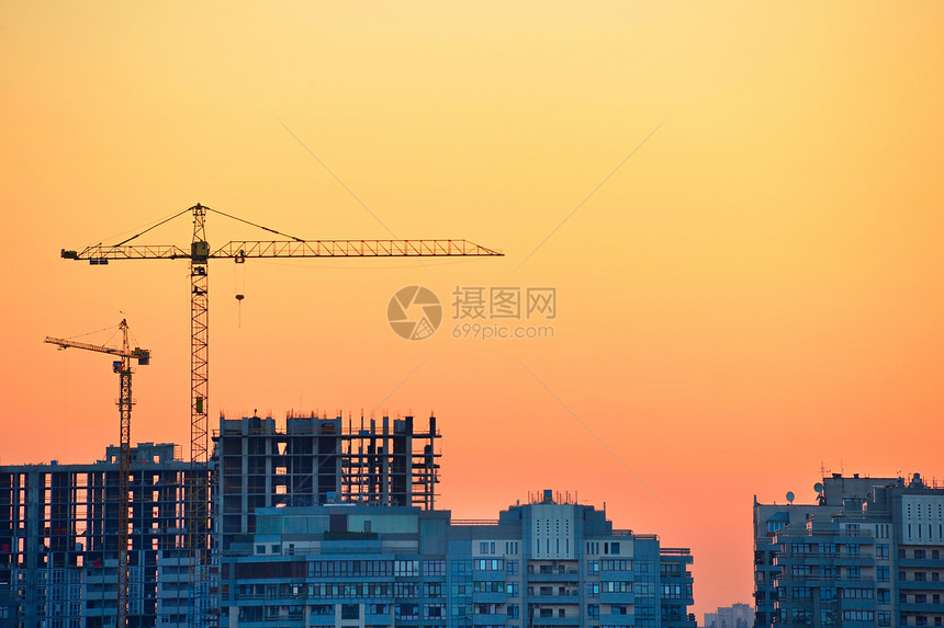 在多彩日落时建筑工地的起重机图片