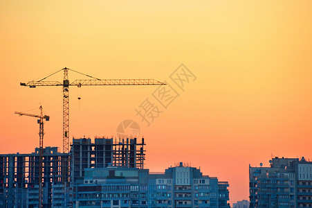 在多彩日落时建筑工地的起重机背景图片