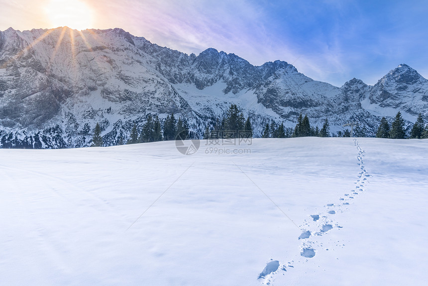 冬季的山峰阳光明媚的高山风景地平线上的奥斯特里亚山峰和地平面上厚的雪毯面有脚印图片