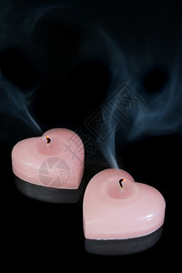 两根粉红蜡烛在黑色背景上粉的心形背景图片