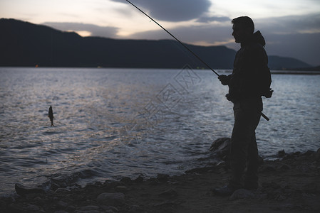 在湖边钓鱼的男子图片