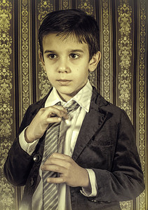 穿旧黑西装打领带的男孩背景图片