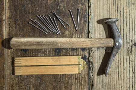 木板上的老锤子钉和木厘米图片