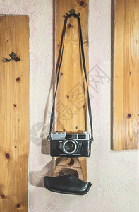 挂在墙上衣架的古老摄影机图片