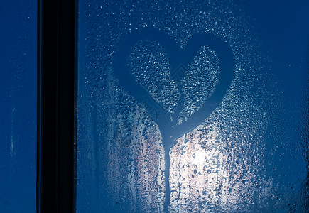 月光穿过窗外满是汗水的玻璃和心形背景图片