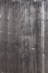 由旧的垂直木板组成的棚墙部分涂有淡色黑灰漆或图片