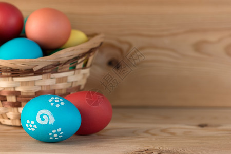在木板上涂彩色的鸡蛋和篮子图片