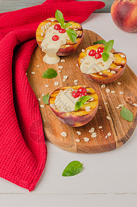 木制桌上加酸奶鹅莓和薄荷叶的烤桃子高清图片