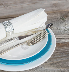 白色和蓝板餐巾布旧木板上的银叉和刀背景图片