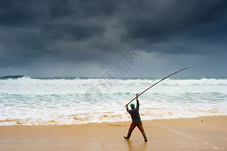 暴风雨下在海滩捕鱼的渔民图片