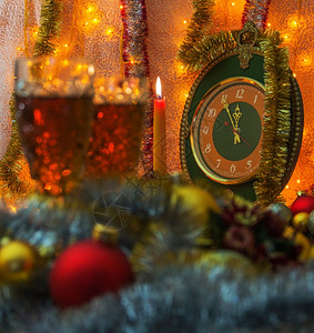 圣诞时钟前景是m2杯圣诞玩具前景脱离焦点在背景蜡烛和时钟中间是5到12无焦点的亮和时间是分钟到背景照亮了garlnd设计图片