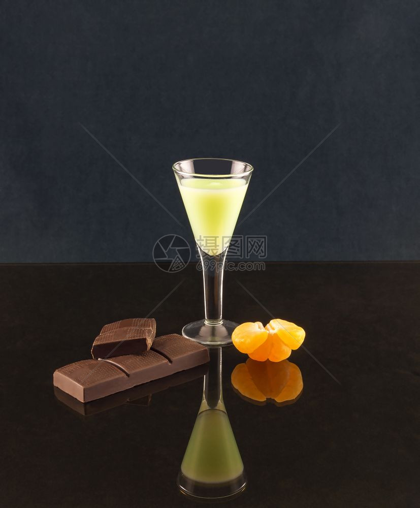 镜子表面反射一个杯子酒巧克力和半橘子图片