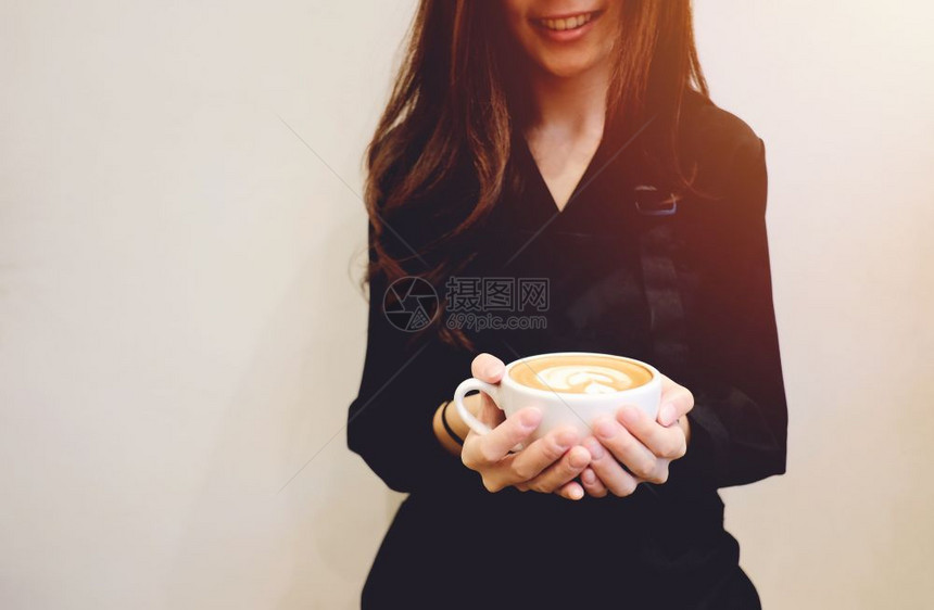 紧握着咖啡杯微笑的女孩图片